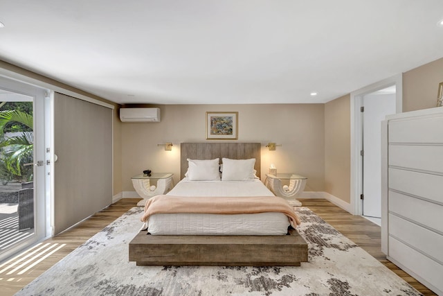 bedroom with light wood-type flooring and a wall mounted AC