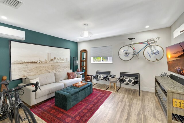 living room with wood-type flooring and a wall unit AC