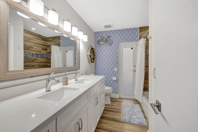 full bathroom featuring wood-type flooring, vanity, toilet, and shower / bath combination with curtain