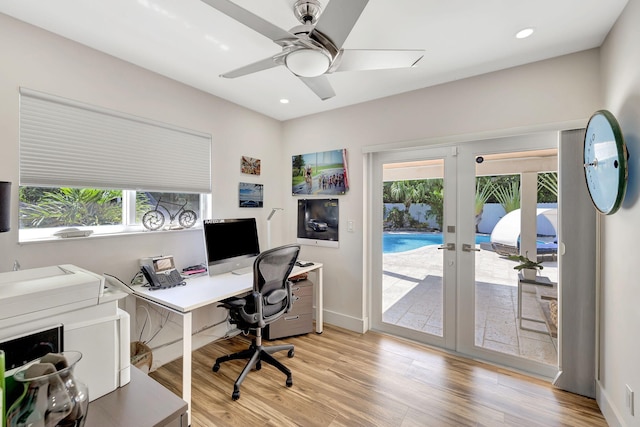 office with light hardwood / wood-style flooring, ceiling fan, and french doors