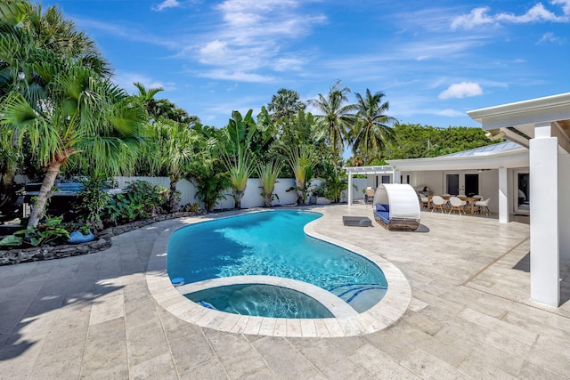 view of swimming pool featuring a patio and an in ground hot tub