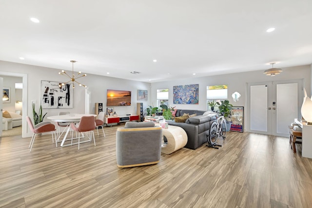 living room with an inviting chandelier and light hardwood / wood-style flooring