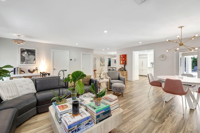 living room with a notable chandelier and light hardwood / wood-style floors