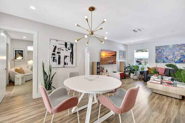 dining space featuring an inviting chandelier and light hardwood / wood-style floors