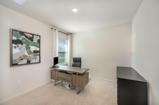 office with visible vents, baseboards, and light colored carpet