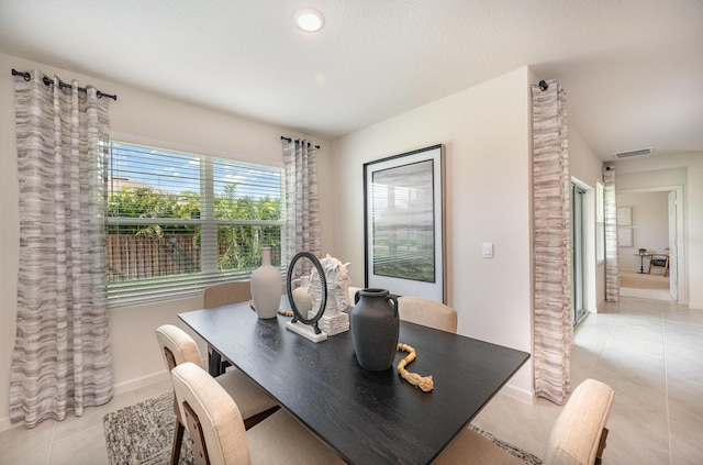 dining room with light tile patterned floors, visible vents, and baseboards