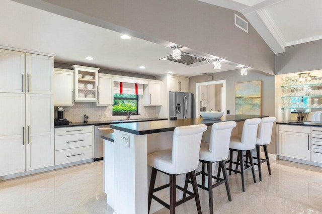 kitchen with white cabinets, a kitchen breakfast bar, sink, and appliances with stainless steel finishes