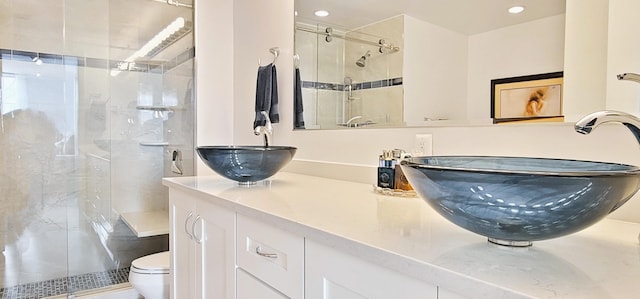 bathroom featuring an enclosed shower, toilet, and vanity