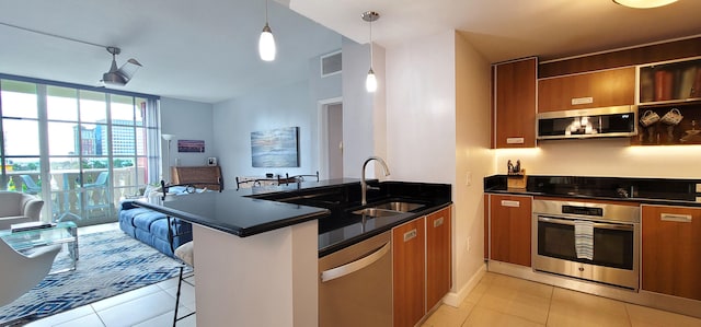 kitchen featuring kitchen peninsula, a breakfast bar area, sink, and stainless steel appliances