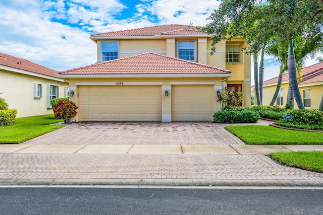 mediterranean / spanish-style house with a garage and a front yard