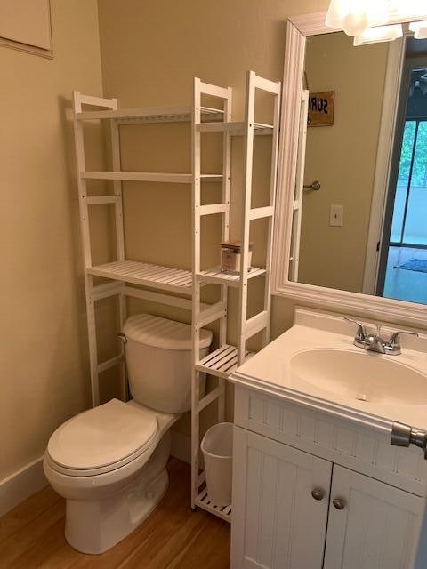 bathroom featuring wood-type flooring, vanity, and toilet