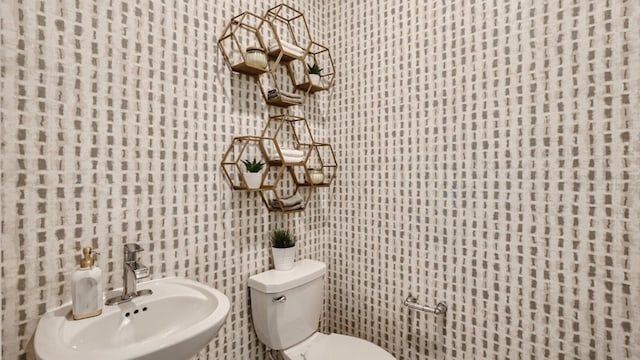 bathroom featuring toilet, sink, and tile walls