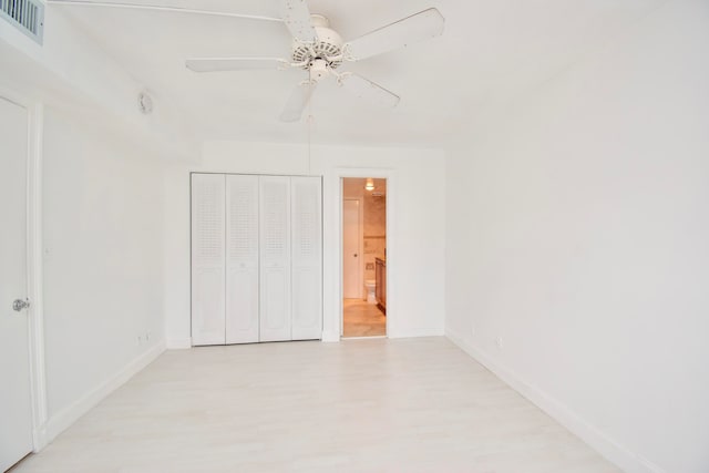 unfurnished bedroom featuring ceiling fan, light hardwood / wood-style floors, and a closet