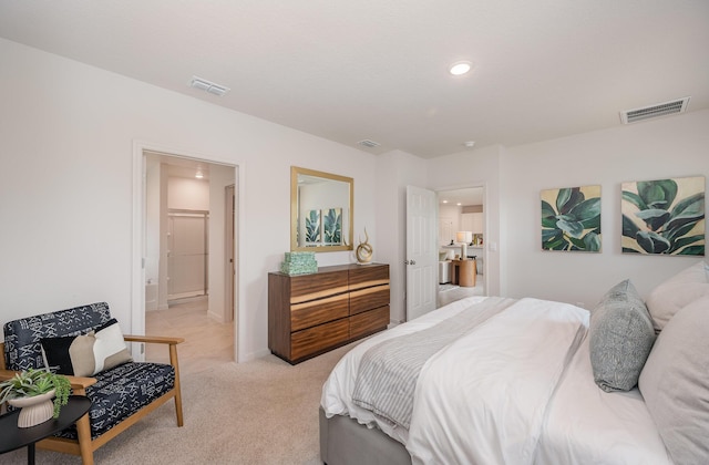 bedroom with light colored carpet and ensuite bath