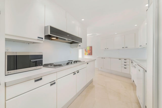 kitchen with light tile patterned flooring, white appliances, exhaust hood, and white cabinetry