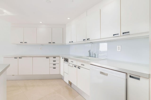 kitchen featuring white dishwasher, sink, and white cabinets