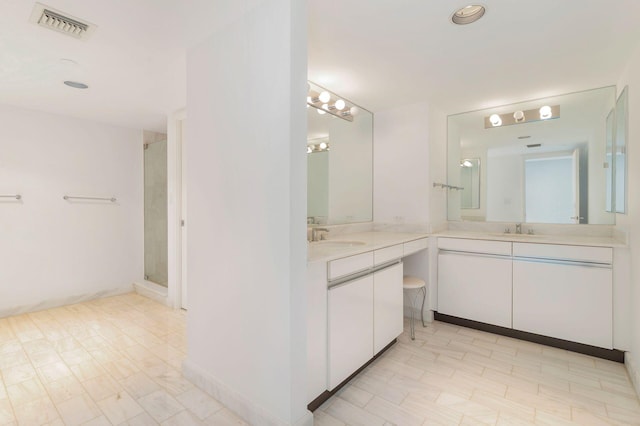 bathroom with a shower with shower door and vanity