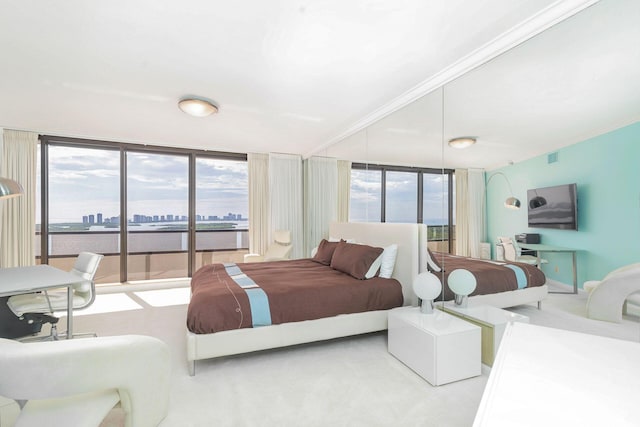 bedroom featuring light carpet and a wall of windows