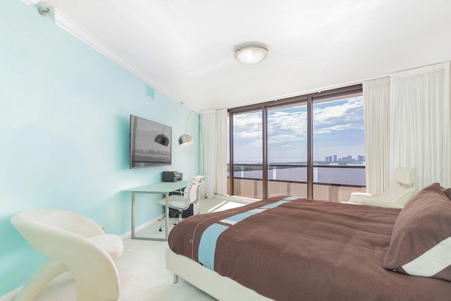 bedroom with ornamental molding, floor to ceiling windows, and carpet