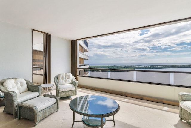 sitting room with a water view and light tile patterned floors