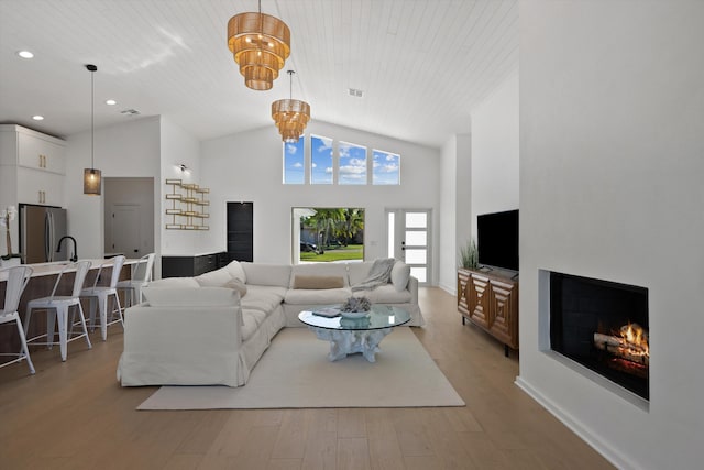 living room featuring wooden ceiling, a notable chandelier, light hardwood / wood-style flooring, and high vaulted ceiling