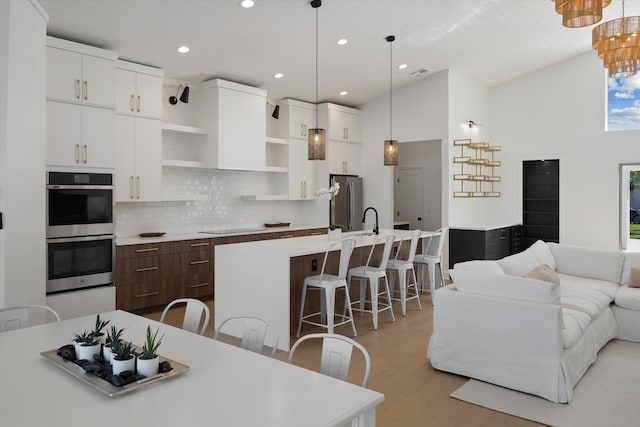 kitchen with an island with sink, stainless steel appliances, and a breakfast bar