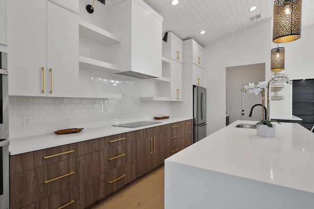 kitchen featuring stainless steel appliances, white cabinetry, light wood-type flooring, and sink