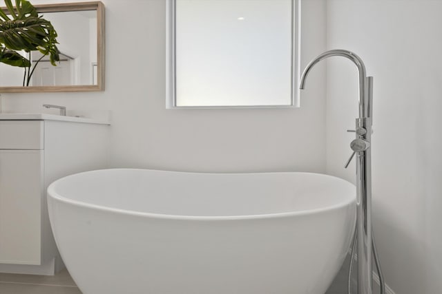 bathroom with vanity, a tub to relax in, and tile patterned floors