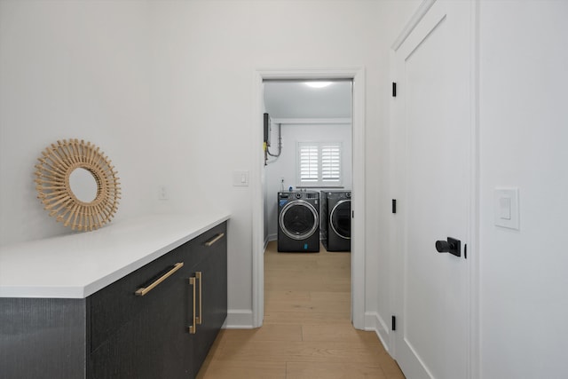 corridor with light wood-type flooring and washing machine and clothes dryer