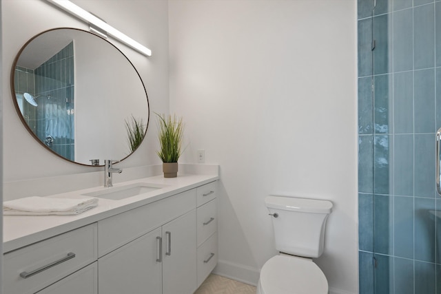 bathroom featuring a tile shower, vanity, and toilet