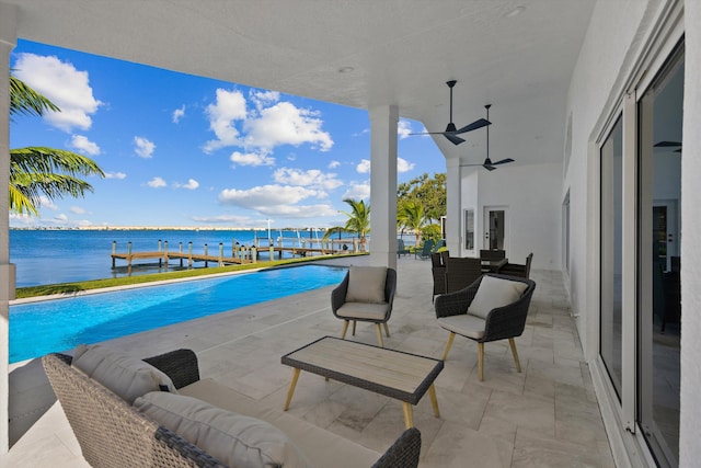 view of swimming pool with ceiling fan, an outdoor hangout area, a patio, and a water view