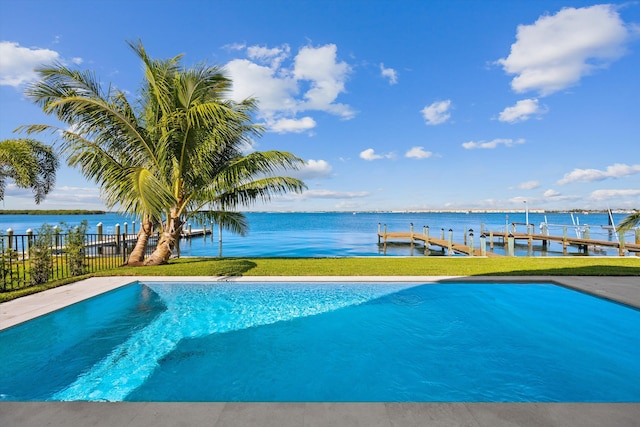 view of pool with a lawn, a boat dock, and a water view