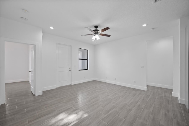 spare room with ceiling fan, a textured ceiling, and light hardwood / wood-style flooring