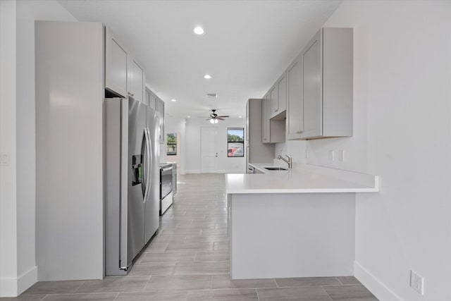 kitchen featuring sink, appliances with stainless steel finishes, kitchen peninsula, and ceiling fan