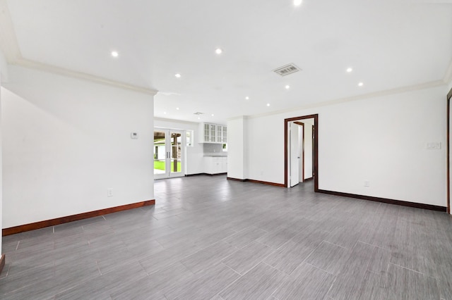 unfurnished living room featuring french doors, light wood-type flooring, and ornamental molding