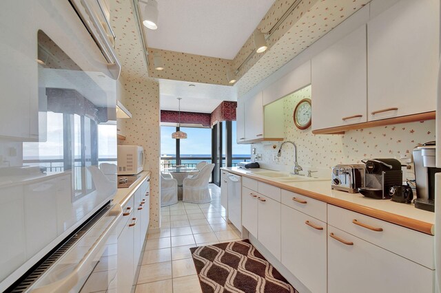 4000 N Ocean Dr Unit 2401, Singer Island, FL 33404 - kitchen with a sink, white appliances, wallpapered walls, light countertops, and light tile patterned flooring