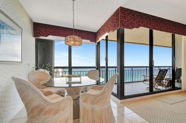 4000 N Ocean Dr Unit 2401, Singer Island, FL 33404 - sunroom featuring wallpapered walls, a water view, tile patterned flooring, and a textured ceiling