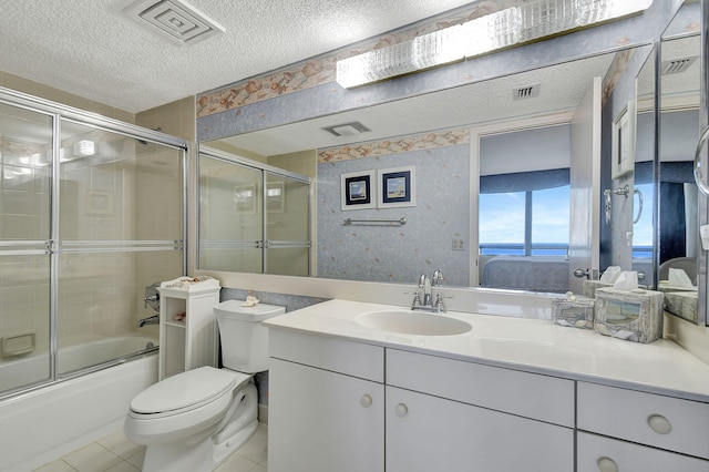 full bathroom with vanity, toilet, a textured ceiling, combined bath / shower with glass door, and tile patterned flooring