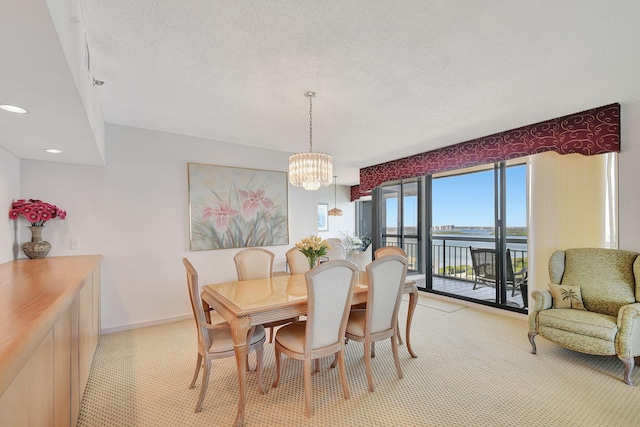 4000 N Ocean Dr Unit 2401, Singer Island, FL 33404 - dining room with a water view, a chandelier, a textured ceiling, baseboards, and recessed lighting