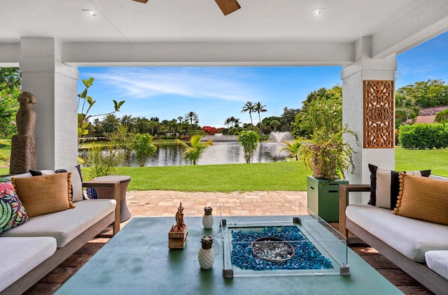 view of patio / terrace with a water view and an outdoor living space with a fire pit