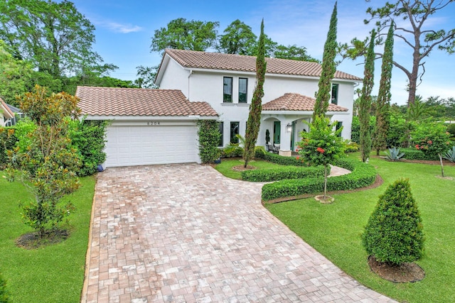 mediterranean / spanish-style home featuring a front lawn and a garage