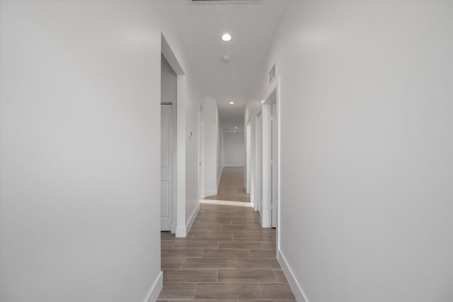 hall featuring light hardwood / wood-style flooring and a textured ceiling