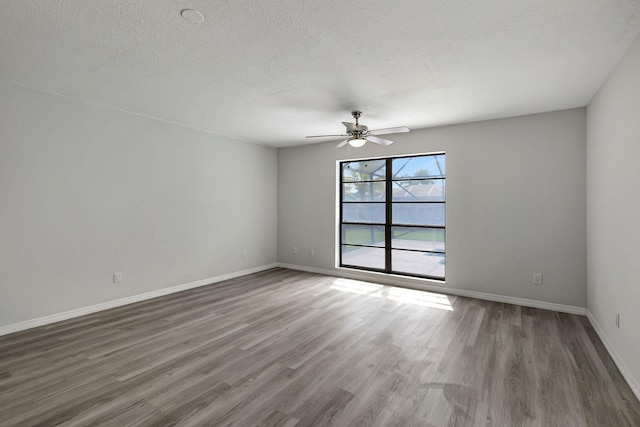 empty room featuring a textured ceiling, dark hardwood / wood-style flooring, and ceiling fan