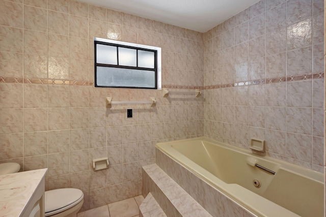 bathroom with tile walls, tile patterned flooring, tiled tub, vanity, and toilet