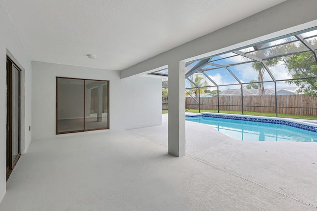 view of pool with a patio and glass enclosure