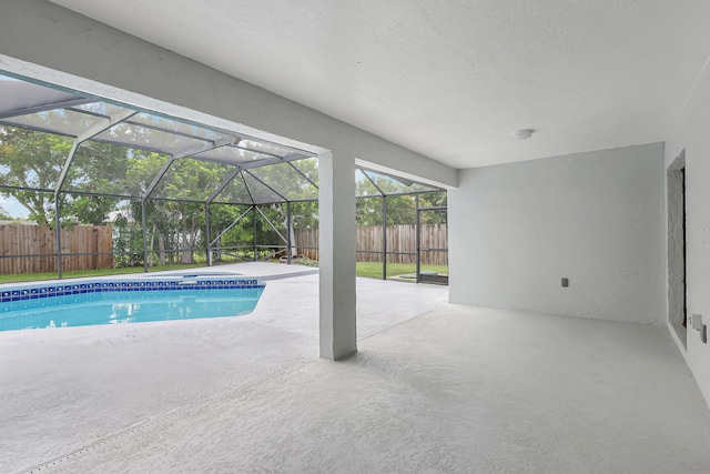 view of pool featuring glass enclosure and a patio area