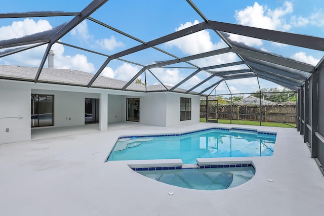 view of swimming pool with glass enclosure and a patio