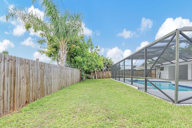 view of yard with a fenced in pool and glass enclosure