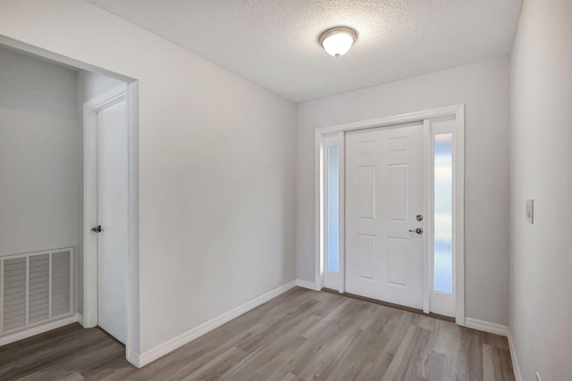 entryway featuring a textured ceiling and hardwood / wood-style floors