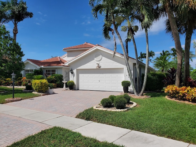 view of front of property with a garage and a front lawn